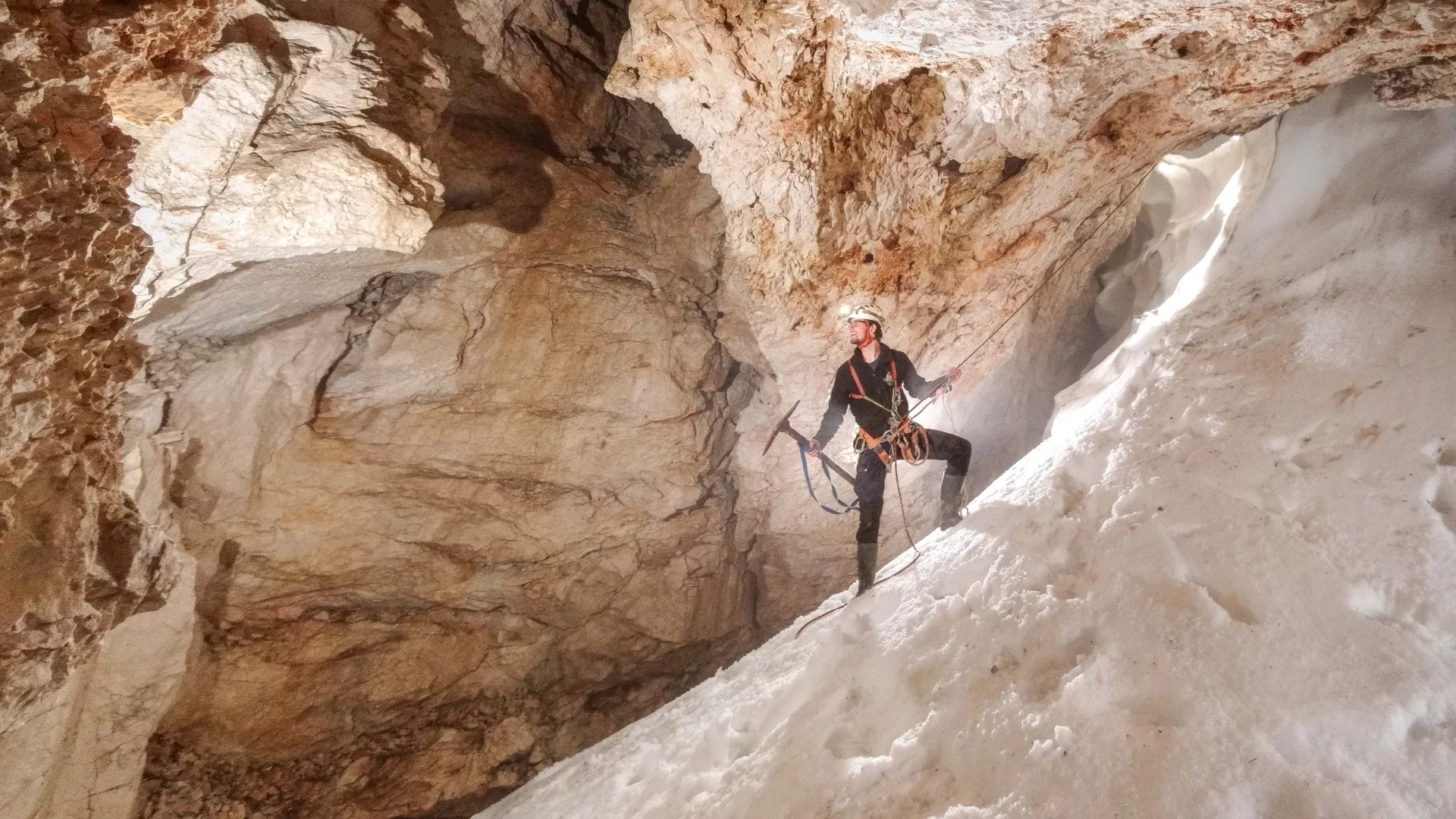 Chris Hayes in M10, an ice cave not yet connected to the main system, but directly above it. Pickaxe in hand, on the way to dig at draughting holes. (Photo used in Descent 300) (© Ben Richards)