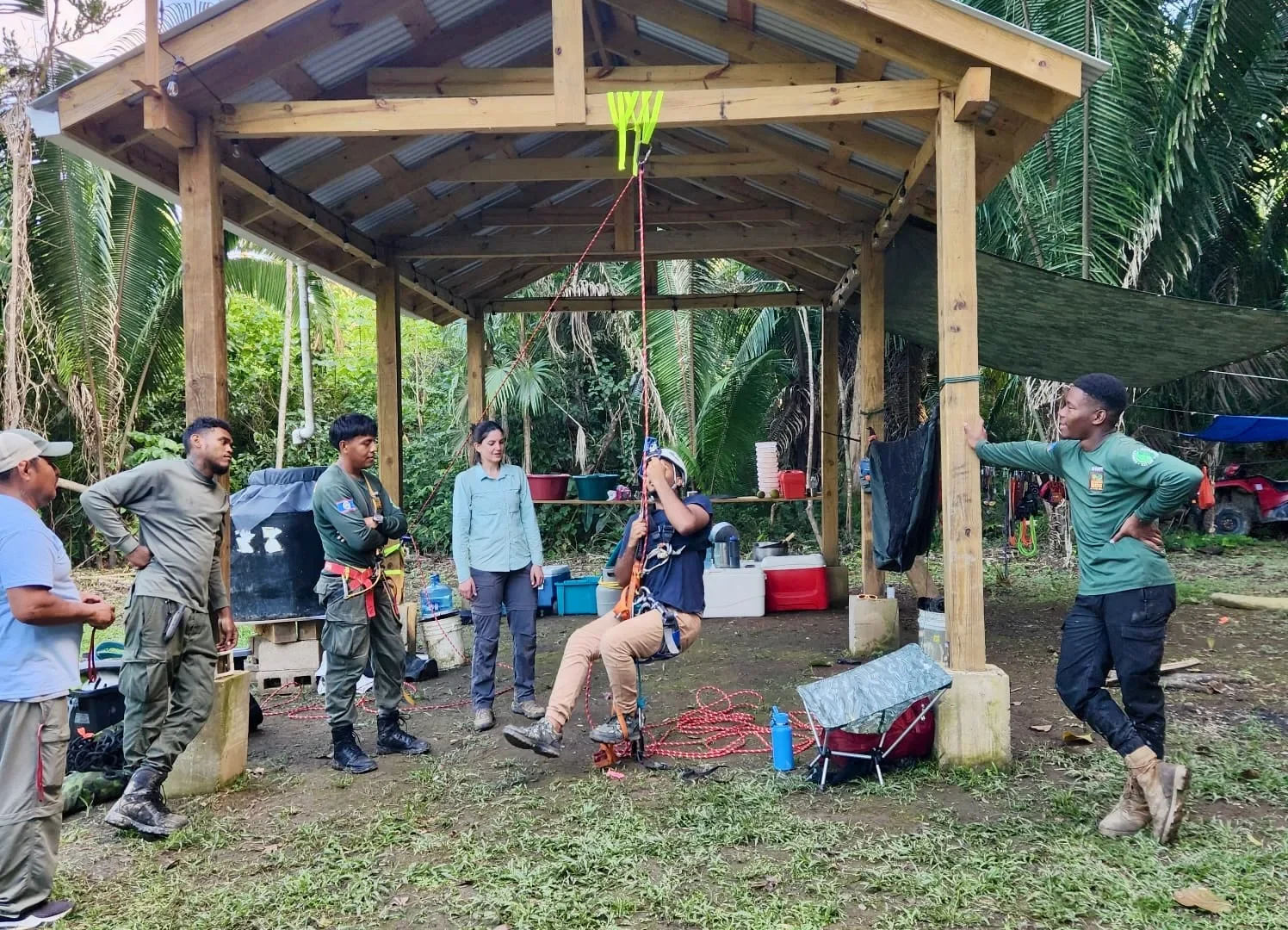 Jessica Ratcliffe, expedition lead and archaeology DPhil student, instructing Gary Zuniga, PA Manager, in Single Rope Technique at camp in Monkey Bay National Park. (© Eli Miller)