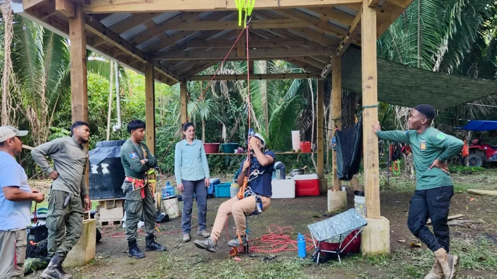 Jessica Ratcliffe, expedition lead and archaeology DPhil student, instructing Gary Zuniga, PA Manager, in Single Rope Technique at camp in Monkey Bay National Park. (© Eli Miller)